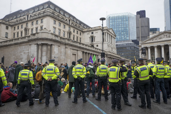 Police officers stand around Extinction Rebellion activists during a demonstration outside the Bank of England last month.