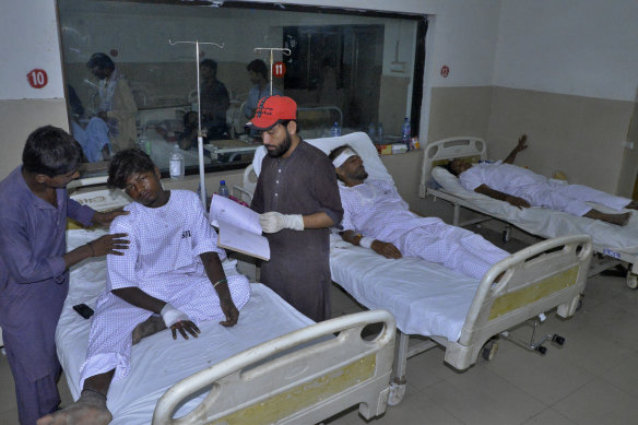 Injured victims of a passenger train derailed incident, are treated at a hospital, in Nawabshah, Pakistan.