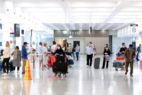 Passengers walk through the international arrivals terminal in Sydney airport in December.