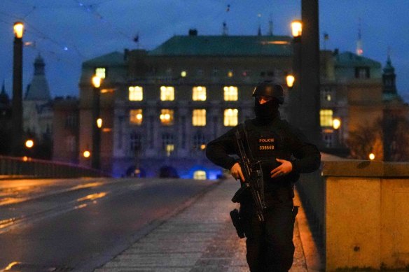 A police officer walks across a bridge over the Vltava river in downtown Prague.