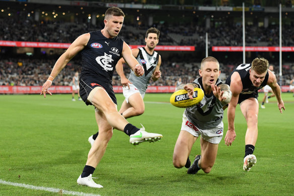 Port’s Hamish Hartlett, right, smothers a kick by Carlton’s Marc Murphy. 