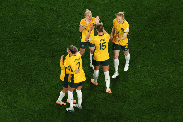 Matildas teammates celebrate after defeating Denmark 2-0 in Sydney.