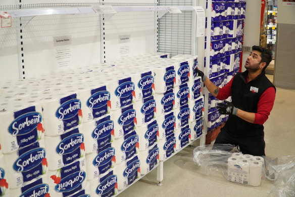 Workers restock shelves at one of Coles' supermarkets on Thursday night. 