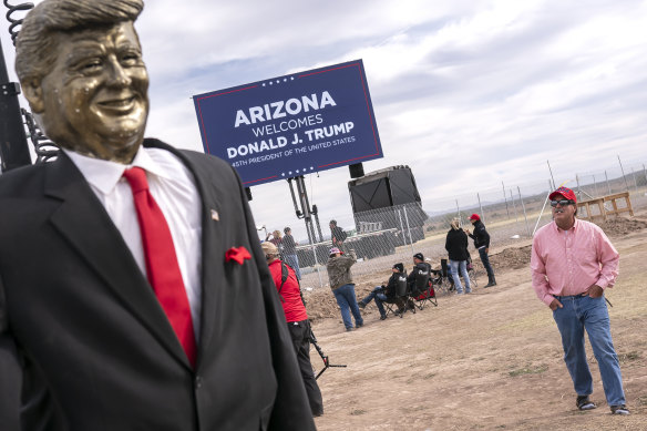 An attendee walks past a statue of Donald Trump before a rally for the former president in Florence, Arizona, in 2022.