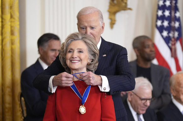 President Joe Biden presents the medal to former secretary of state Hillary Clinton.
