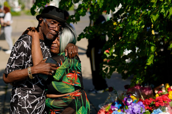 People embrace outside the scene of the Buffalo massacre.