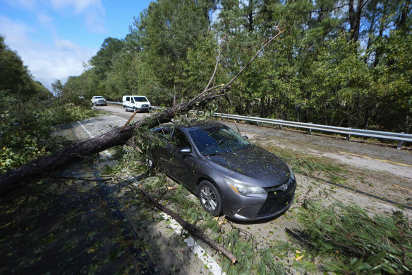 A tree rests on an abandoned car on the Interstate 20 in the aftermath of Hurricane Helene. 