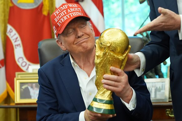 President Donald Trump holds the FIFA World Cup Winners Trophy during an announcement at the White House Oval Office on Friday.