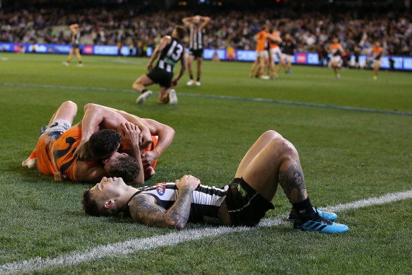 Agony and ecstasy: Magpie Jamie Elliott laments on the siren as GWS celebrate. 