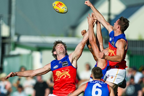Ryan Lester of the Lions spoils from behind over Sam Darcy of the Bulldogs and Harris Andrews of the Lions.