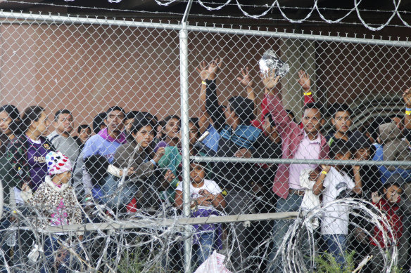 Migrants from Central America wait for food in a pen erected by US Customs officers in El Paso, Texas in 2019.