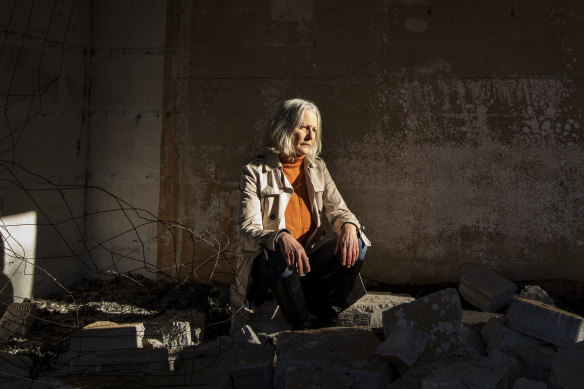 Jann Gilbert sits in the ruins of her Mallacoota home in June.
