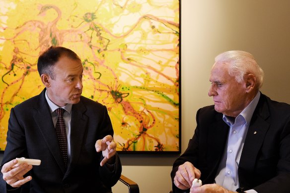 Atomo Diagnostics founder John Kelly, left, shows investor Lang Walker the self-testing blood kit that is already being used for HIV, and which is being pursued for testing COVID-19.