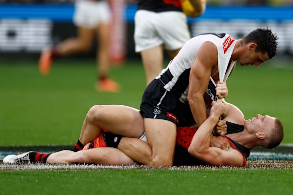 Scott Pendlebury of the Magpies and Ben Hobbs of the Bombers wrestle during the Anzac Day game.