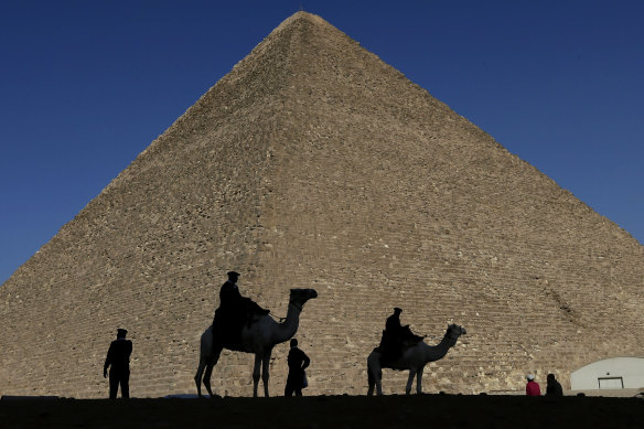 Policemen are silhouetted against the Great Pyramid in Giza.