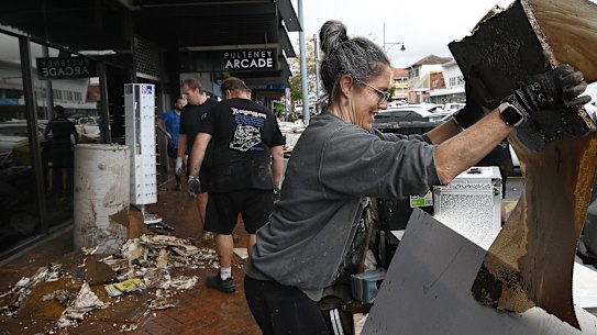 Locals start cleaning out shops and businesses along Pulteney Street in Taree.