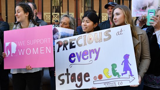 Anti-abortion protesters hold signs during a rally outside NSW Parliament house.