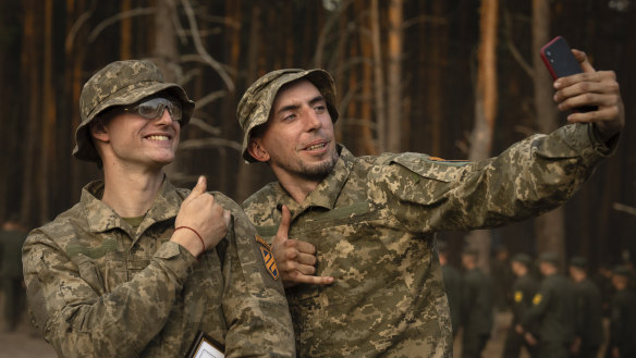 Newly recruited soldiers of the 3rd assault brigade take selfie to mark the end of their training at a military base close to Kyiv.