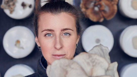 Barrett with a grey oyster mushroom grown on site at the Future Food System sustainability-showcase home in Federation Square.