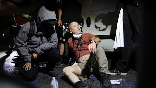 Protestors carried photographer to safety after he was shot with a plastic bullet.