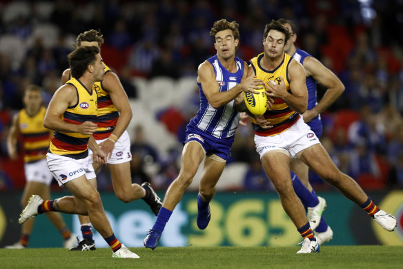 North Melbourne’s Jy Simpkin and Adelaide’s Darcy Fogarty clash.