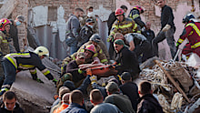 Rescuers carry out an injured man from an apartment building in Pryluky, Ukraine, hit during a Russian air attack on Wednesday, October 7.