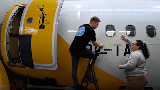 MicroTau partnerships manager Dylan Callender (left) and head of engineering Rebecca Lodin (right) install a sample of MicroTau’s sharkskin drag reducing material on a section of an Airbus aircraft at the Sydenham site.