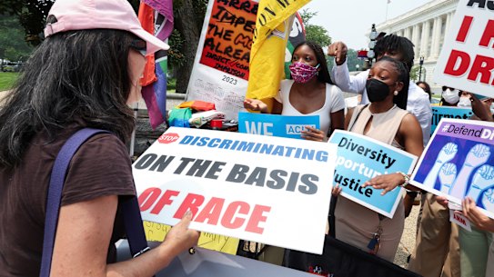 Demonstrators for and against the US Supreme Court decision to strike down race-conscious student admissions programs at Harvard University and the University of North Carolina confront each other, in Washington.