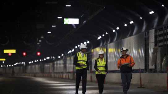 Premier Dominic Perrottet, Minister for Metropolitan Roads Natalie Ward and Transurban’s Terry Chapman walk the WestConnex M4-M5 Link tunnel on Thursday.