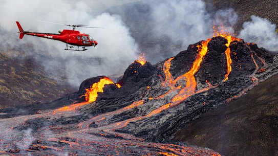 A helicopter flies close to a volcanic eruption which has begun in Fagradalsfjall near the capital Reykjavik on March 20, 2021 in Fagradalsfjall, Iceland.