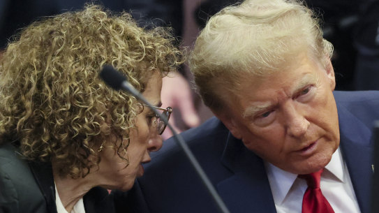 Trump confers with a lawyer during the hearing.