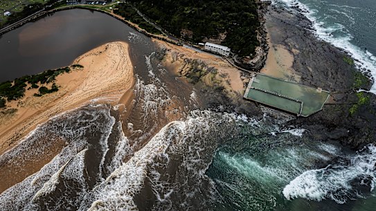 Water rushes out of Narrabeen Lagoon into the ocean. Narrabeen Beach has been closed due to ongoing pollution from the record rainfall.