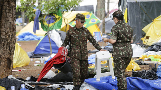 Soldiers help clear out an encampment set up by supporters of former Brazilian President Jair Bolsonaro outside army headquarters in Brasilia, Brazil, Monday, Jan. 9, 2023, the day after Bolsonaro supporters stormed government buildings in the capital.