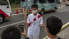  A torch-bearer has his photo taken during the Tokyo Olympic Games Torch Relay on Saturday.
