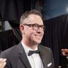 Greig Fraser walks backstage at the Oscars after winning.