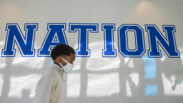 COVID nation: A young boy walks down a hallway to get tested for COVID-19 at a high school in the Algiers neighbourhood of New Orleans on Monday.