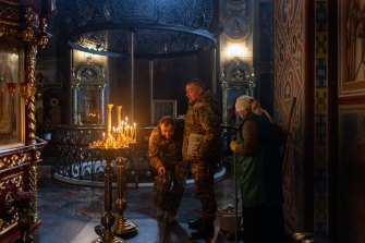 Worshippers in Kyiv’s gold-domed St Michael’s pray for a peaceful resolution. 
