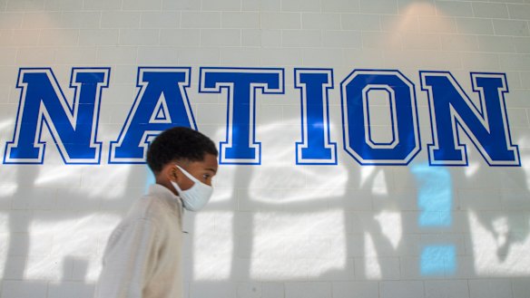 COVID nation: A young boy walks down a hallway to get tested for COVID-19 at a high school in the Algiers neighbourhood of New Orleans on Monday.