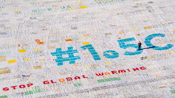 A giant postcard made of contributions from some 125,000 individual postcards containing messages to fight climate change stands on the Aletsch glacier in Switzerland.
