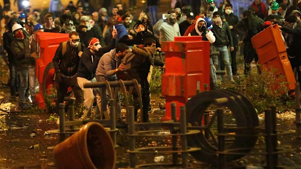 Anti-government protesters clash with riot police near Parliament square in downtown Beirut on Sunday.