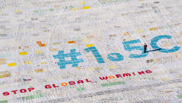 A giant postcard made of contributions from some 125,000 individual postcards containing messages to fight climate change stands on the Aletsch glacier in Switzerland.