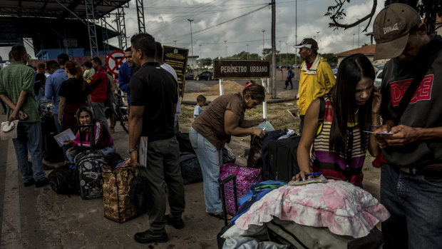 Venezuelans wait to register with immigration authorities after crossing the border into Pacaraima, Brazil.