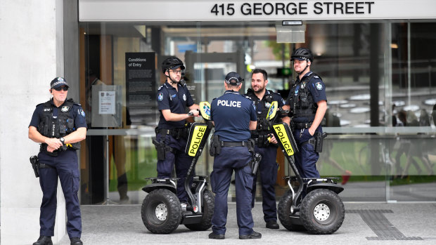 Police are seen standing guard outside the Queen Elizabeth II Courts of Law building after the building was evacuated because of a bomb threat.