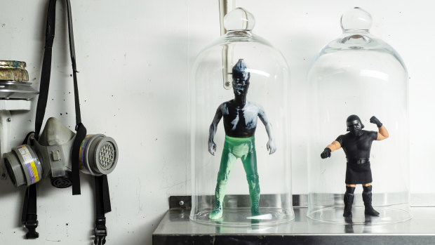 'Graffiti for wimps': Artisanal action figures made by David Healey are displayed on a shelf next to a respirator at his studio in Manhattan.