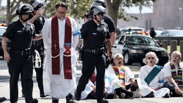 A  clergy member is arrested during a civil disobedience protest against the separation of families, in front of Federal Courthouse in Los Angeles.