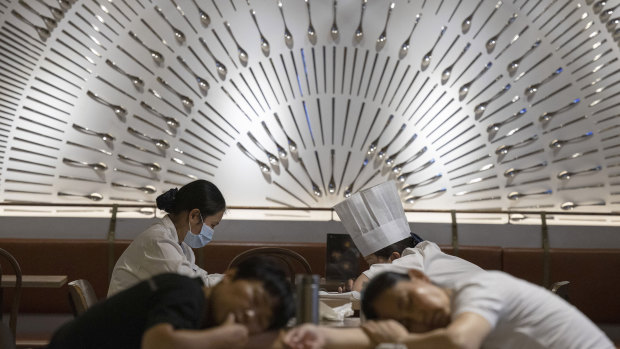 Restaurant workers nap on tables at a restaurant in a shopping centre in Beijing.