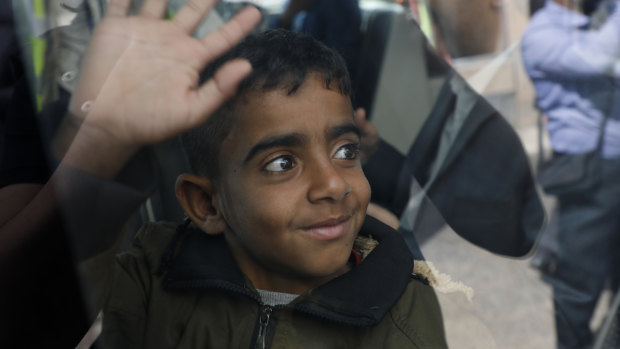 A Yemeni boy waves from inside a bus before boarding a United Nations plane at Sanaa International airport. Eight patients and their families were flown to Egypt and Jordan to receive life-saving specialised care.