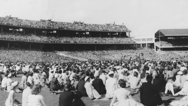 A crowd at the MCG in 1959 wait to hear Billy Graham preach the gospel.