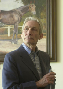 The Rolling Stones drummer and horse breeder Charlie Watts toasts with champagne after his horse won a race at the Sluzewiec horse racing track in Warsaw on May 25, 2002. 