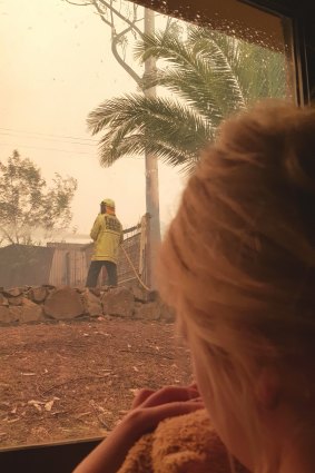 Mia Atkin, 6, watches on as her firefighter father Mike Atkin battles to save their Batemans Bay home.